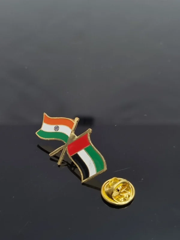 Metal lapel pin with polished finish on a plain background.