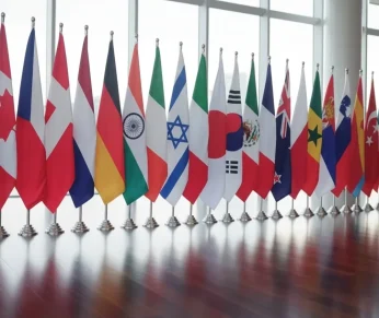 Row of international flags displayed together at an event.